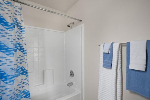 A bathroom with a blue shower curtain and towels.