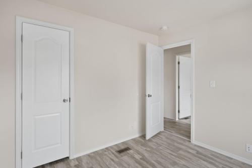 An empty room with white walls and wooden floors.