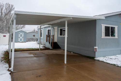 A gray mobile home with a covered patio.
