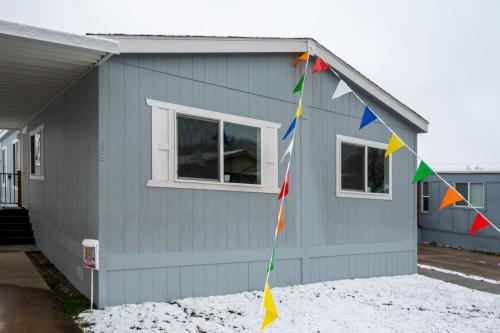 A mobile home with colorful flags on the side of it.
